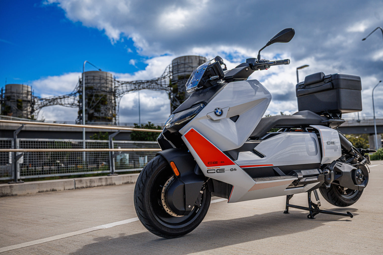 BMW CE04 on footpath with cylos in background and blue sky