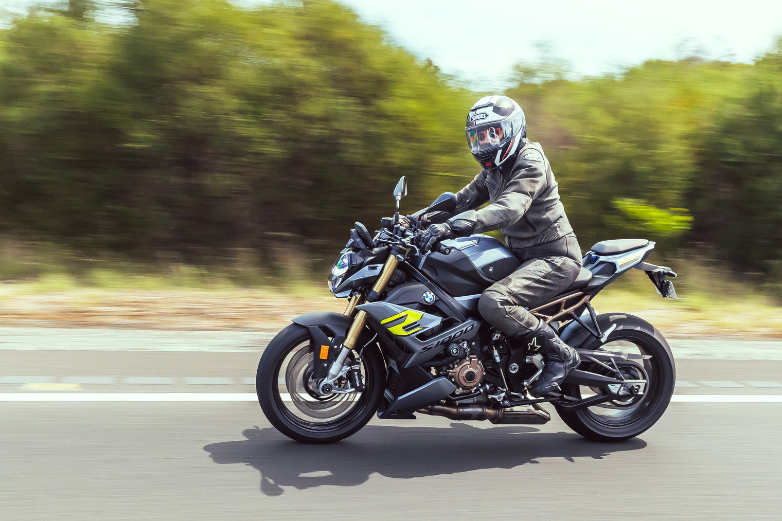 Women riding BMW S1000R on a freeway in leathers
