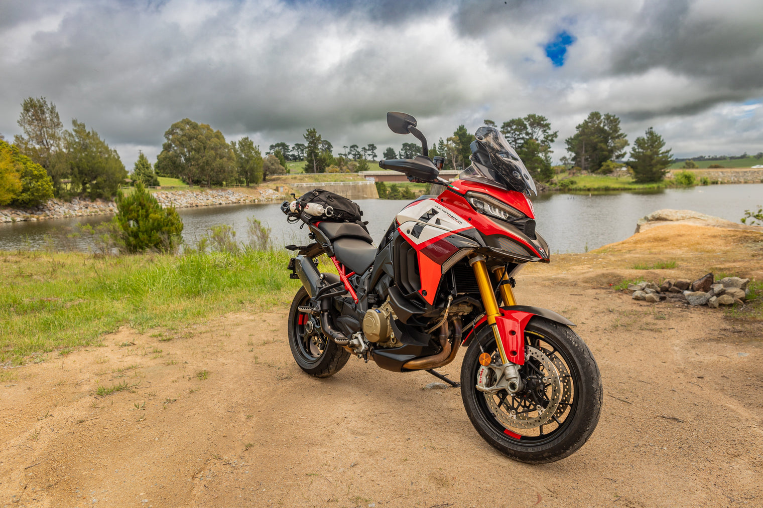 Ducati Multistrada V4 near lake on dirt road