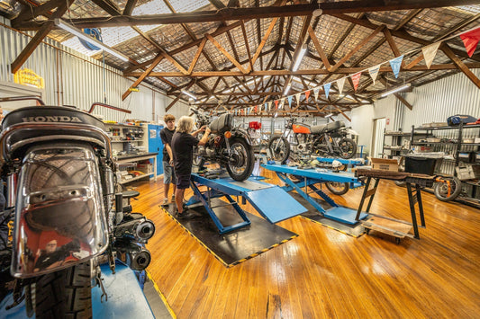 two mechanics working on a Honda CB550 at Art Shokai Garage