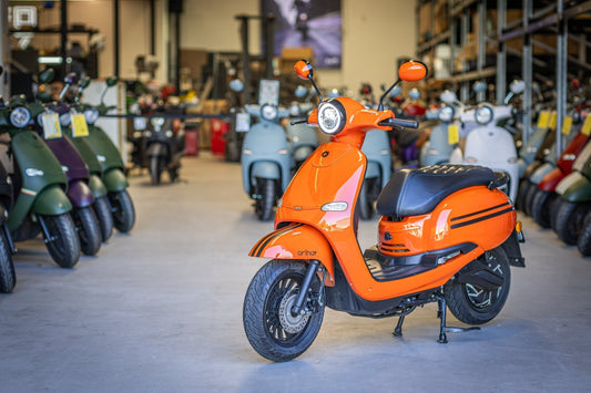 Orange FONZ Electric scooter sitting in warehouse with other scooters behind