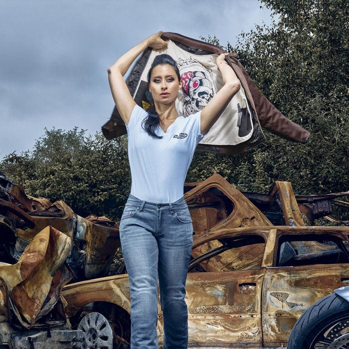 Women putting on SEGURA ETERNAL WOMENS MOTORCYCLE JACKET MAROON